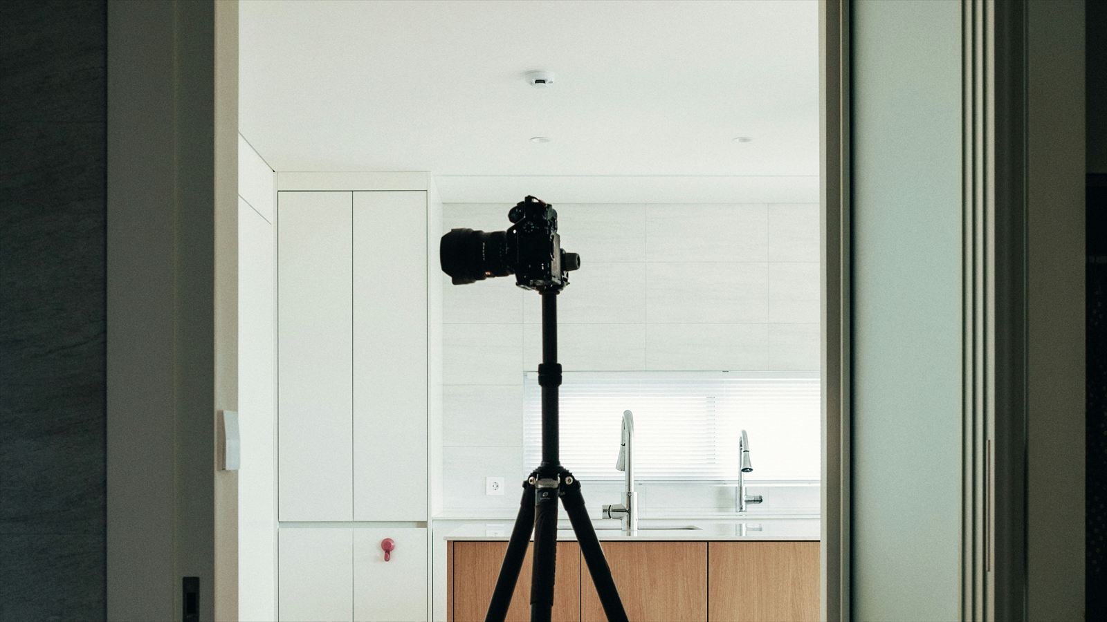 Camera on a tripod in an open kitchen interior