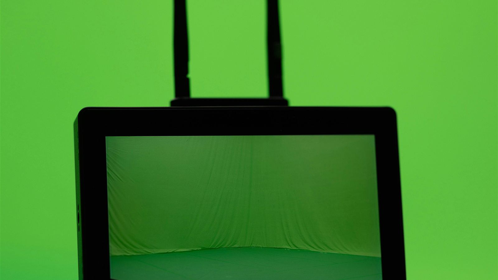 Camera monitor framing a wrinkled green-screen stage