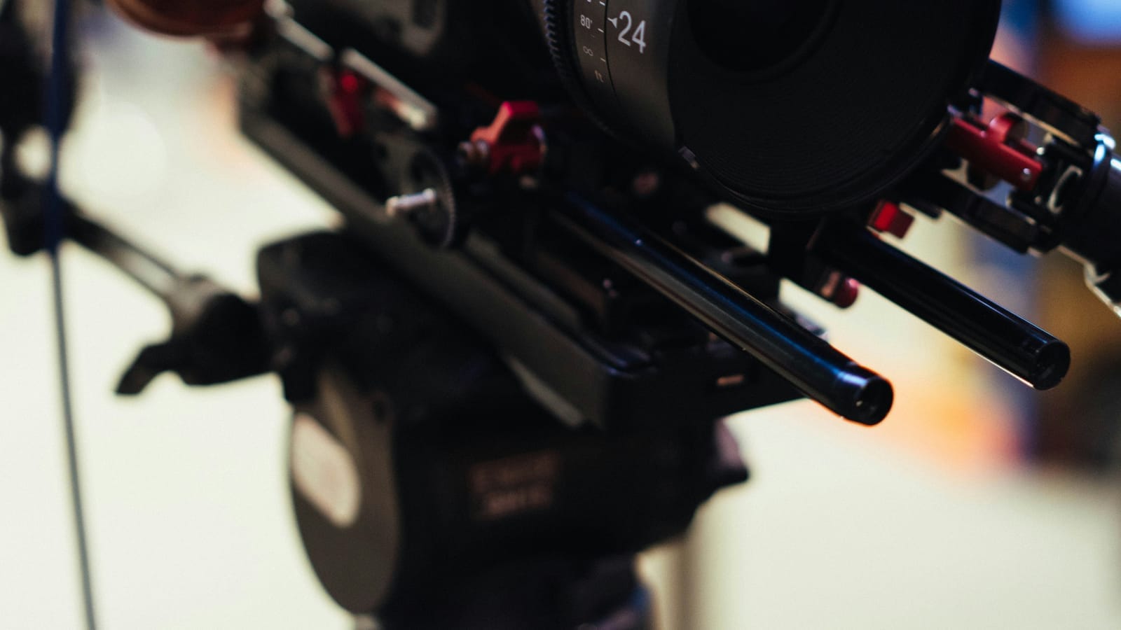 Close-up of a cinema camera rig with lens support rails
